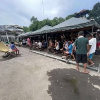 People gathered along a covered outdoor walkway